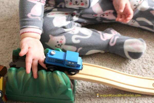 toddler playing with train on ramp