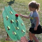 Play an apple tree gross motor game to get kids moving and practicing numbers. Homemade yarn apples add a special touch.