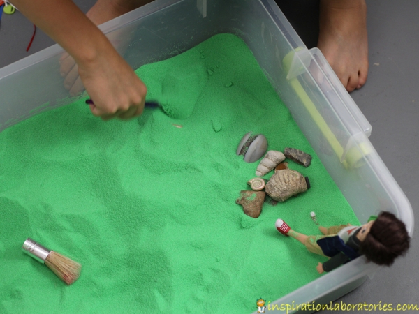 Set up a fossil hunting sensory bin with sand and fossils for your Lottie Dolls.