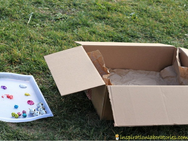Set up a jingle bell drop painting activity outside in a box.