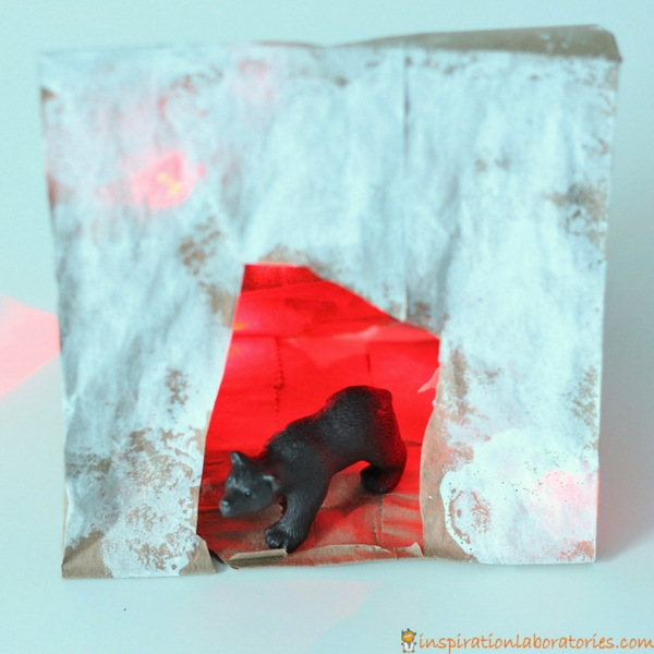 Add lights to a paper bag bear cave craft.