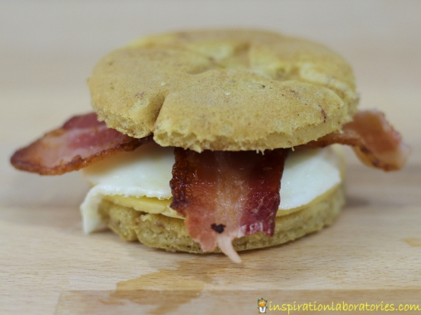 Make a delicious cinnamon roll breakfast sandwich with bacon, egg, and cheese.
