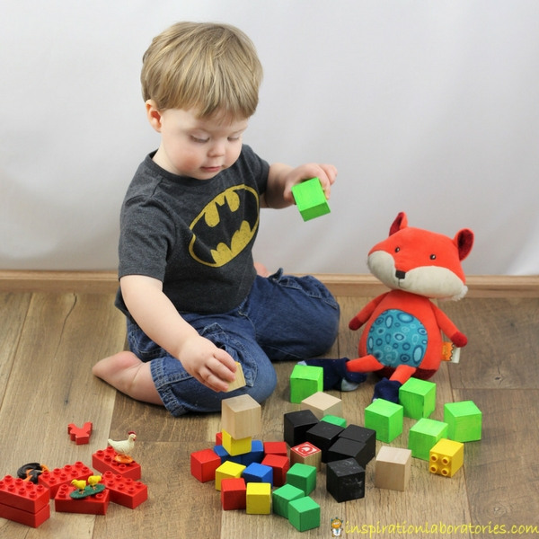 toddler stacking blocks with a toy fox