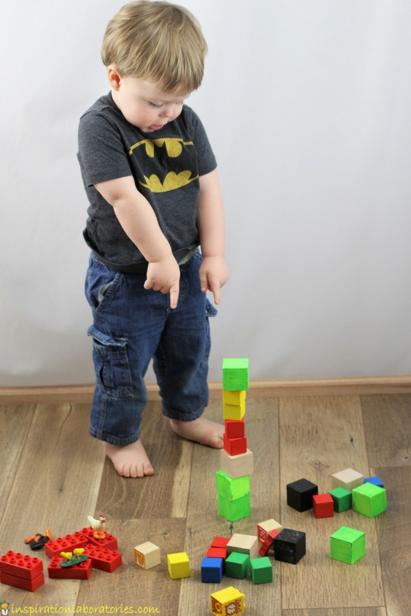 toddler pointing at a stack of blocks
