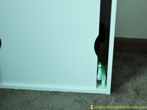 toy dinosaur hidden in cabinet