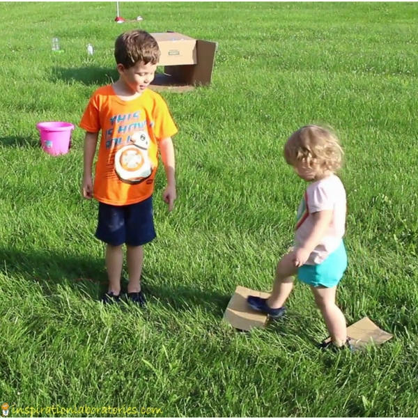 two kids on a homemade obstacle course outside