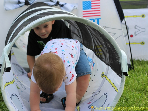 2 kids playing in a tunnel of a Pacific Play Tents space tent