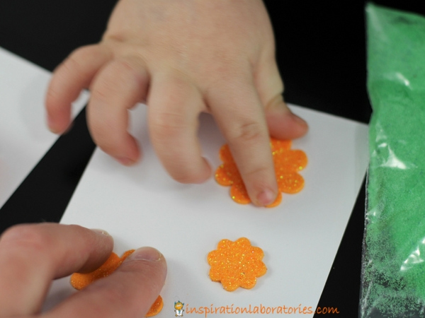 hands touching orange flower stickers
