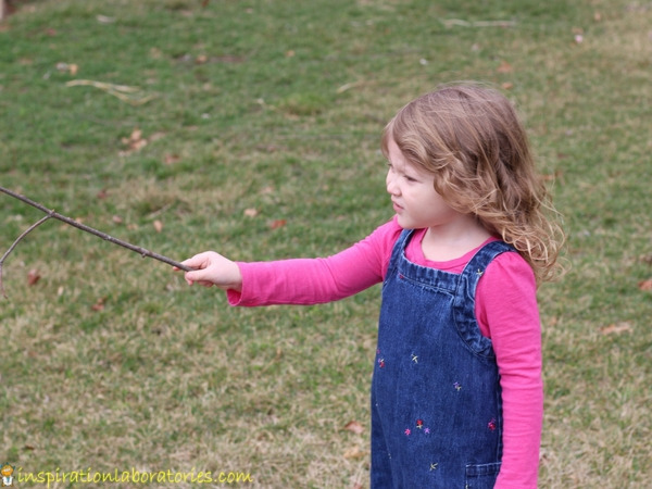 preschool girl holding a stick