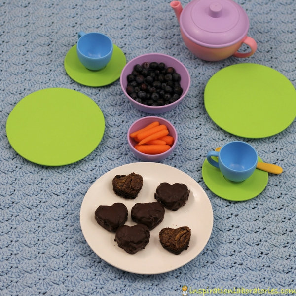 children's tea party dishes with brownies, blueberries, and carrots