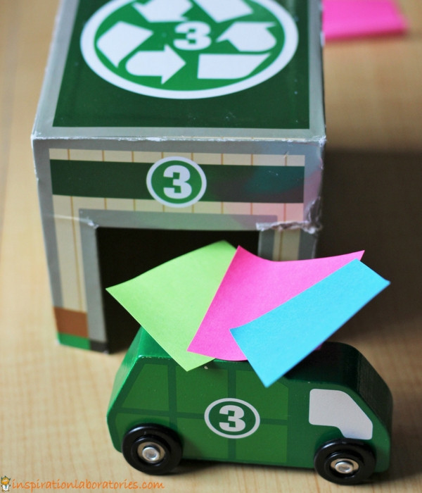 green toy recycling truck with 3 post-it notes on top