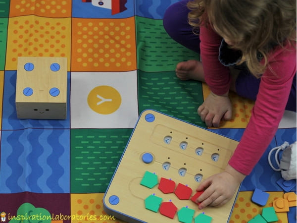 preschool girl programming Cubetto, a wooden cube robot 