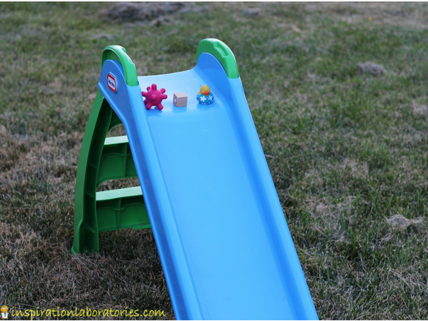 toddler science exploration with 3 objects on a slide