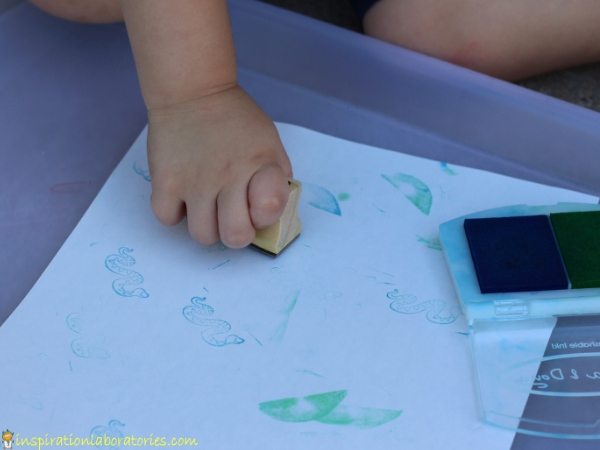 toddler stamping a piece of paper