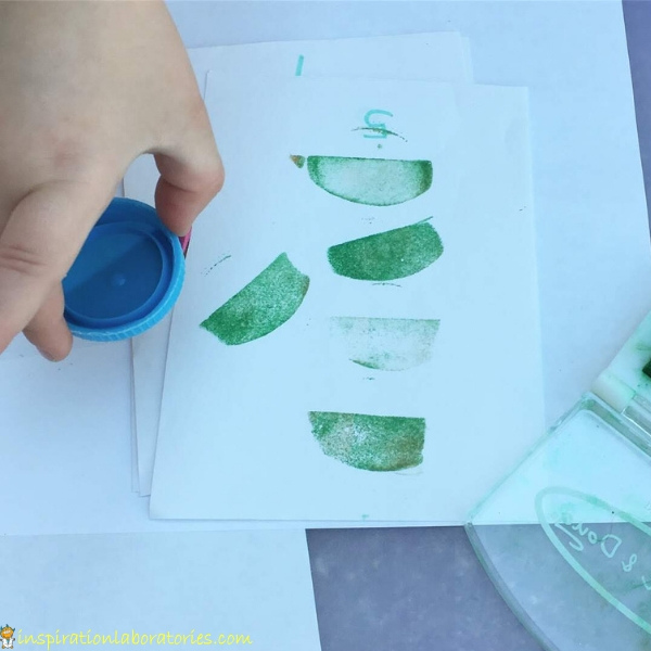 child stamping paper with DIY mouse stamp