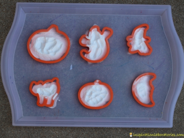 Halloween cookie cutters and baking soda on tray