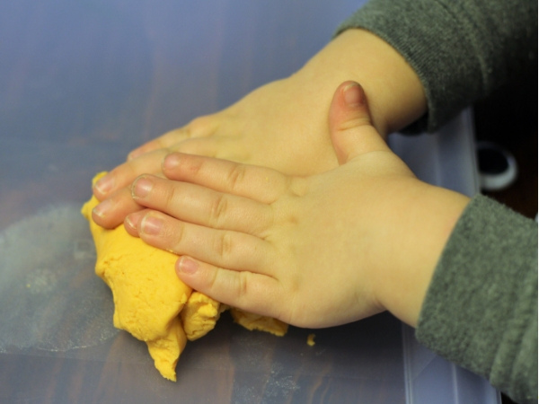 hand smashing sweet potato play dough
