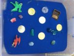 Dragon Treasure Sensory Bin – set up a simple sensory bin with colored sand, treasures, and dragons.