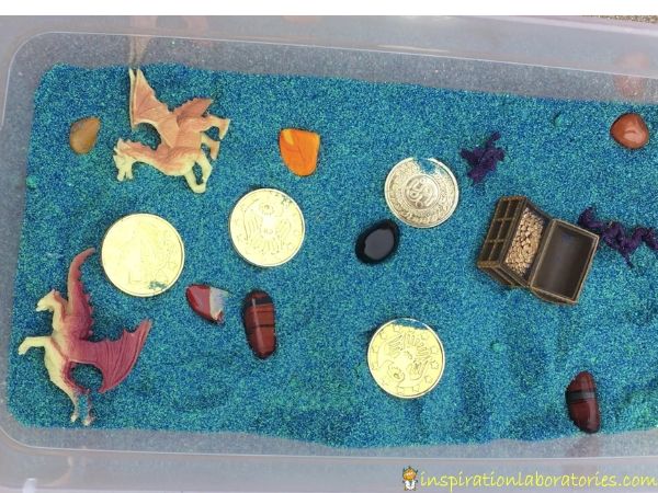 Dragon Treasure Sensory Bin - set up a simple sensory bin with colored sand, treasures, and dragons.