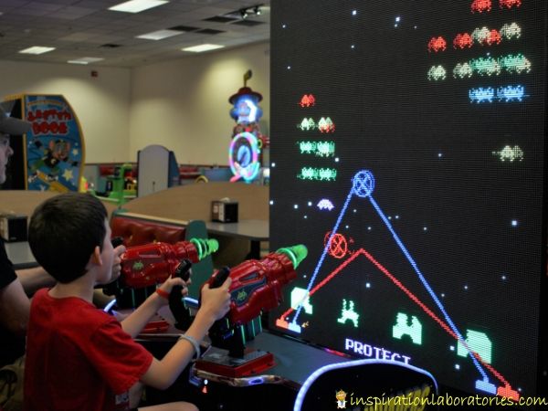 playing space invaders at Chuck E. Cheese
