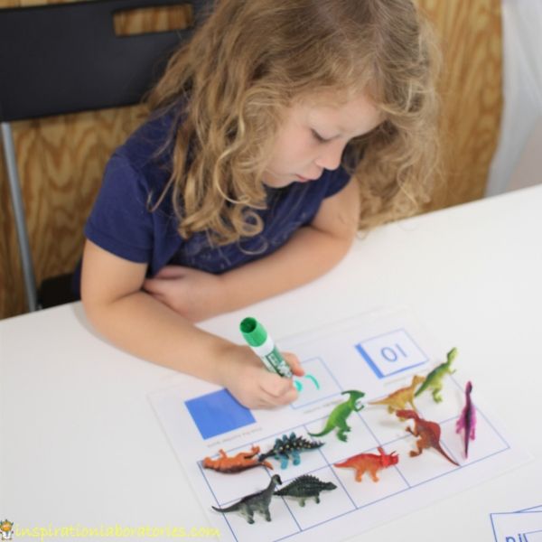child writing the number 10 on dinosaur ten frame math printable