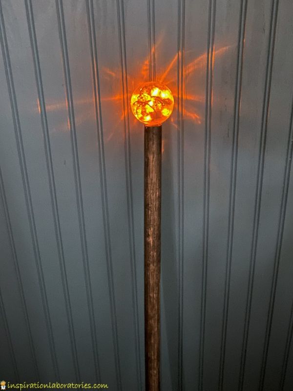 wizard's staff made from a dowel rod, plastic ball, and LED Halloween lights
