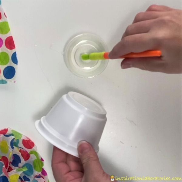 brush glue on yogurt cup to decorate with tissue paper