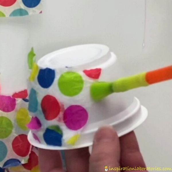 add pieces of tissue paper to yogurt container