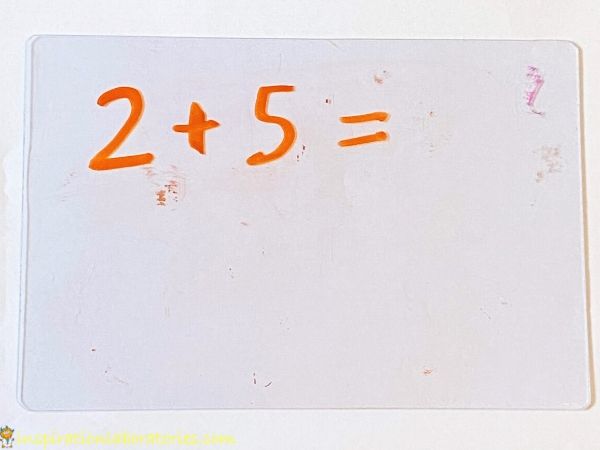 2 + 5 = written on dry erase board