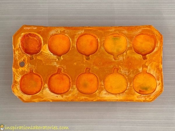 frozen baking soda colored orange in pumpkin ice cube tray